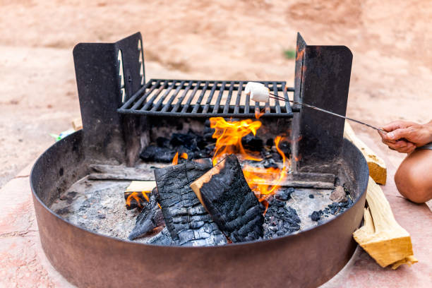 Roasting white marshmallow on fire flame in campground campfire grill in desert landscape in Goblin Valley State Park Roasting white marshmallow on fire flame in campground campfire grill in desert landscape in Goblin Valley State Park 16286 stock pictures, royalty-free photos & images