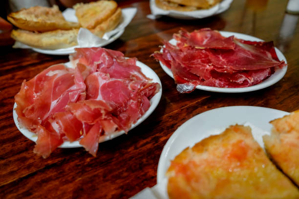 Close up shot of Jamón ibérico, Cecina meat and Spanish tomato bread above wooden table