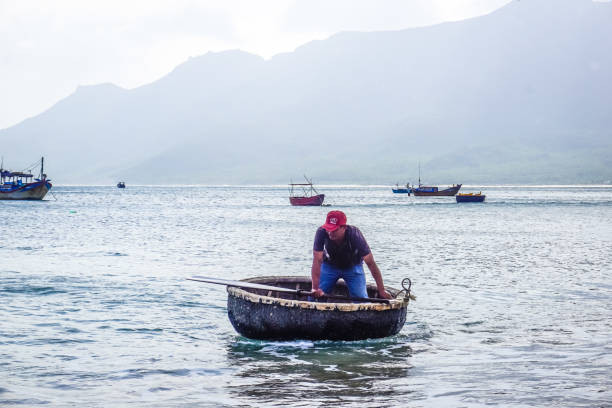 Khanh Hoa Province, Vietnam - February 12, 2018: A man in a traditional Vietnamese boat