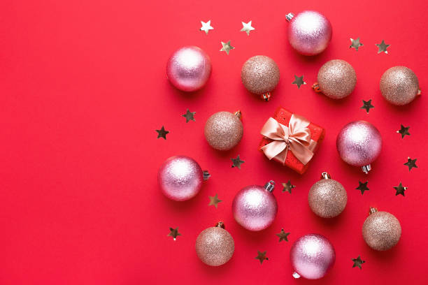 tarjeta de navidad creativa con bolas de oro y regalo envuelto sobre fondo rojo, espacio de copia, diseño minimalista - 5487 fotografías e imágenes de stock