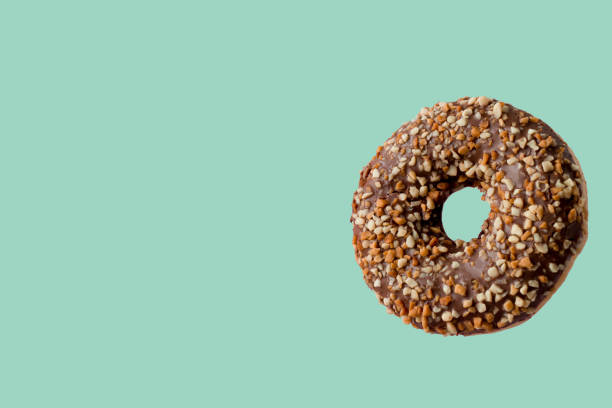 istock chocolate donut with peanut on a mint green background 1177890247