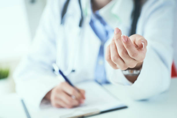 istock Female doctor explaining patient symptoms or asking a question as they discuss together in a consultation. Doctor held out his hand to the patient close-up. 1177892168