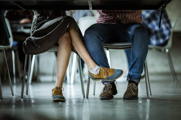 istock Unrecognizable couple flirting under the table. 1177892353