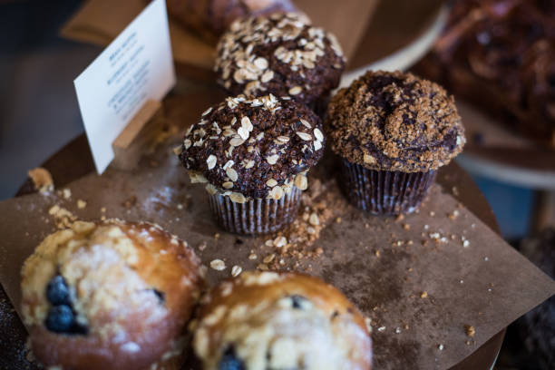 muffins zum verkauf in einem café auf einer rustikalen holzkulisse - cereal bar stock-fotos und bilder