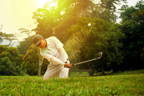 гольфист чиппинг из песчаной ловушки - golf swing golf golf club golf ball стоковые фото и изображения