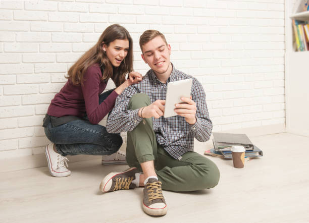 istock Guy and girl students sit on the floor 1177894197