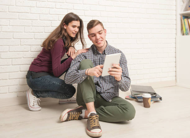 istock Guy and girl students sit on the floor 1177894218