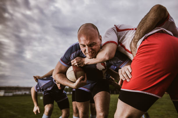 istock Rugby player making an effort while trying to pass rivals on a match. 1177895821
