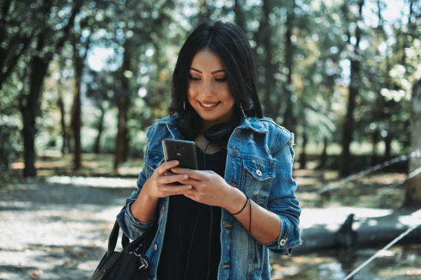 istock Woman using a smart phone outdoors 1177895867