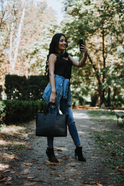 istock Woman using a smart phone outdoors 1177896019