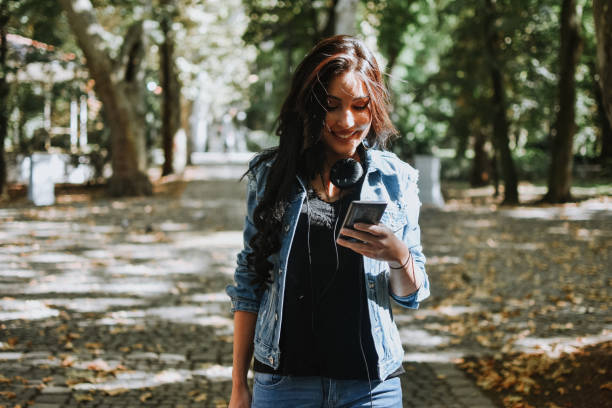 istock Woman using a smart phone outdoors 1177896188