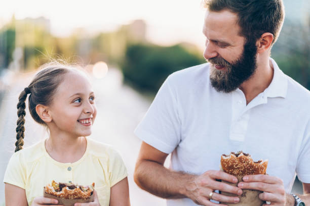 istock Father with daughter eating fast food 1177897504