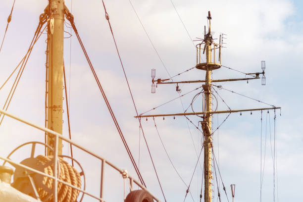 ship mast of frigate, longboat or navy battleship. metal mast pole. ship awaits captain at docks. lowered sails, blue sky on background. - skeg imagens e fotografias de stock