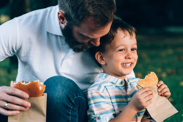 istock Father consoling crying son with delicious burger 1177897590