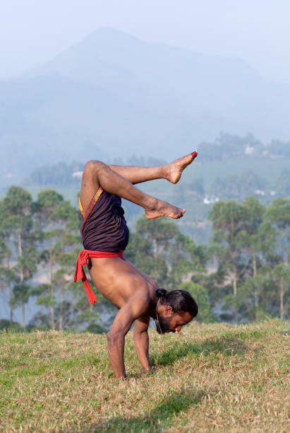 istock Indian man doing handstand outdoors in Kerala, South India 1177900461