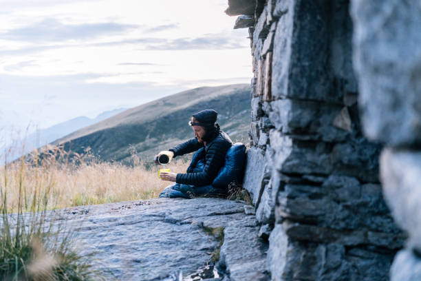 istock Man prepares hot beverage in sleeping bag 1177903426