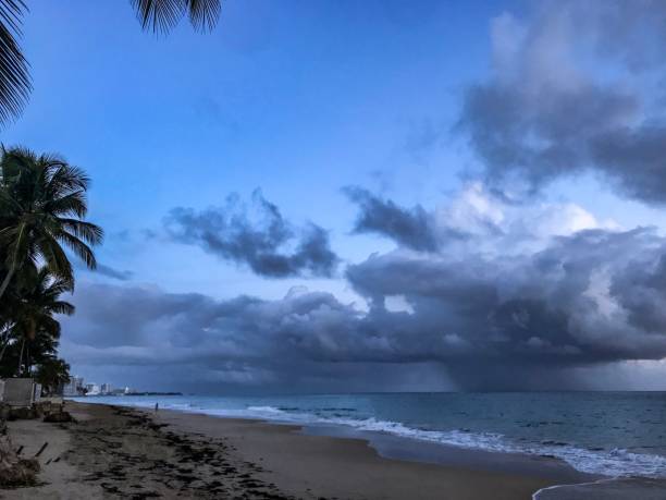 hermosas nubes dramáticas sobre una playa puertorriqueña al atardecer - costa rican sunset fotos fotografías e imágenes de stock