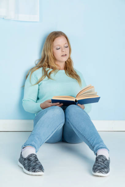 istock Blonde lady in her 20s reading a book 1177904671
