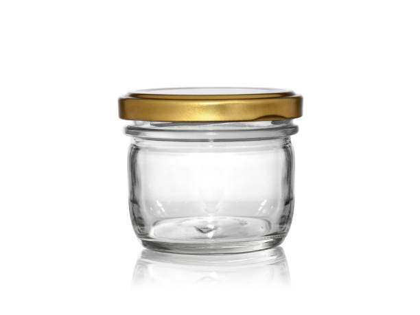 istock a small glass jar with a metal lid on a white background with reflection 1177905150
