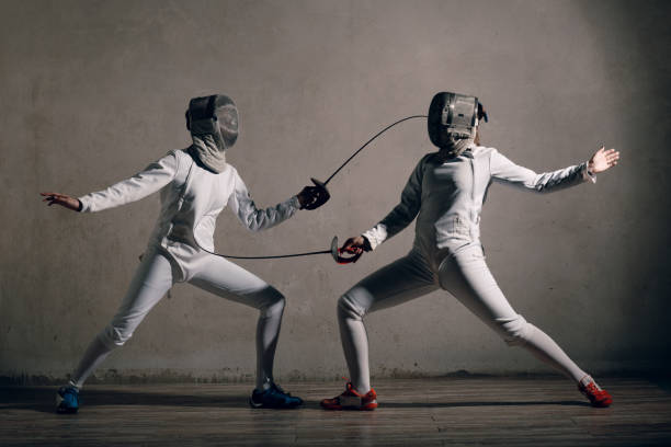 mujer esgrimista con espada de esgrima. concepto de duelo de fencers. - fencing sport athlete sword fotografías e imágenes de stock