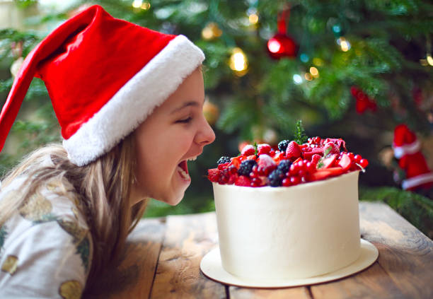 pastel de navidad decorado con bayas y niña - fruitcake christmas cake cake christmas fotografías e imágenes de stock