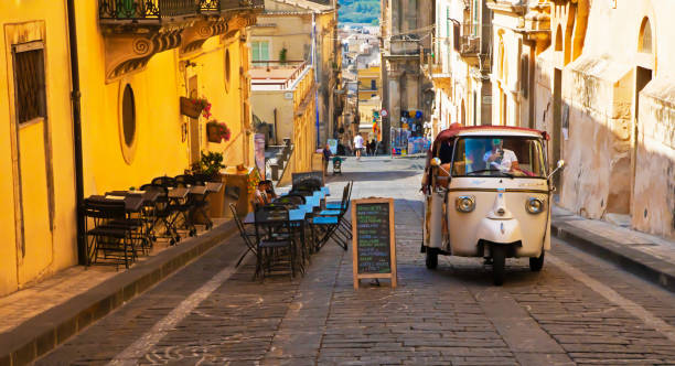 calle vieja de noto con coche piaggio, italia - piaggio fotografías e imágenes de stock