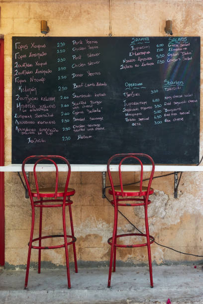 greek menu with price on chalkboard at street cafe - greek culture bar restaurant greece imagens e fotografias de stock