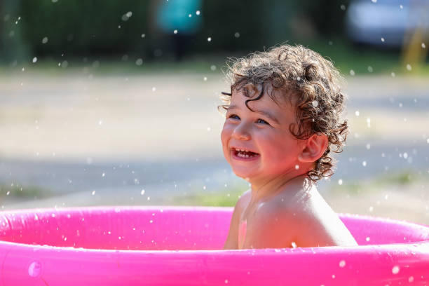 istock Baby boy in plastic little swimming pool. 1177911477