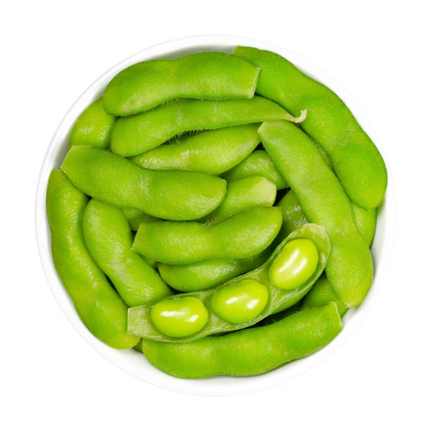 grüne sojabohnen in der hülse, edamame, in weißer schüssel - soybean bean edamame pod stock-fotos und bilder