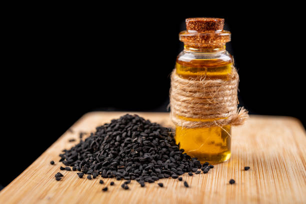 healthy, cold pressed black cumin oil. ingredients for a healthy diet in a modern kitchen. dark background. - caraway imagens e fotografias de stock