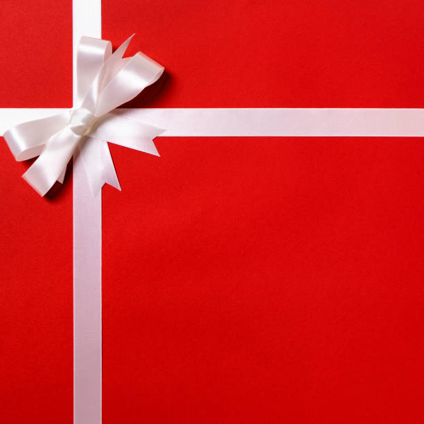 istock Gift wrap, white ribbon bow, red paper background, copy space 1177914953