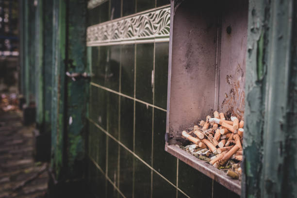 Cigarette bin on the tiled exterior wall of an abandoned bar