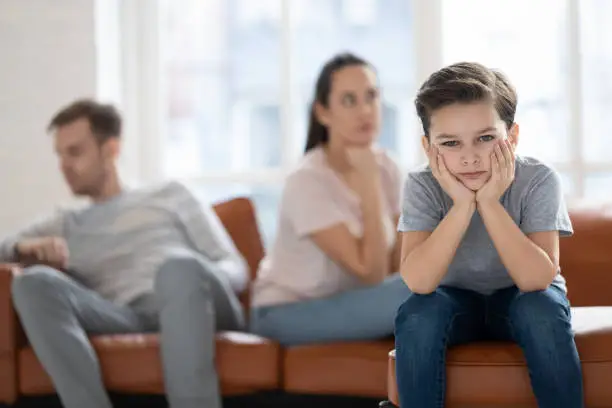 Photo of Upset child boy looking at camera sad about parents fights