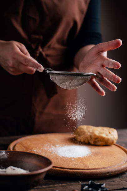 istock Woman sprinkling flour on gingerbread dough 1177917227