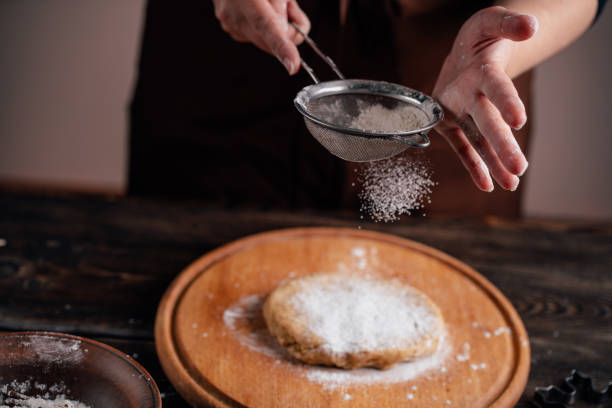istock Woman sprinkling flour on gingerbread dough 1177917229