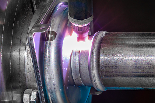 TIG welding automatically of steel products, product is turning while torch is welding the metal parts together