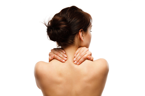 Woman massaging back pain on white background.  “Image is not body shape retouched”