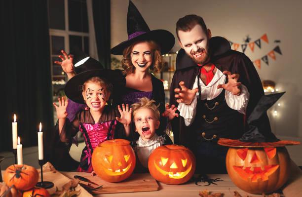 père heureux de mère de famille et enfants dans des costumes et le maquillage sur l'halloween - halloween famille photos et images de collection