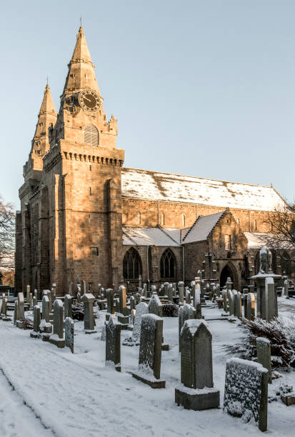 a view of st machar's cathedral and cemetery in winter time covered with snow - uk cathedral cemetery day imagens e fotografias de stock