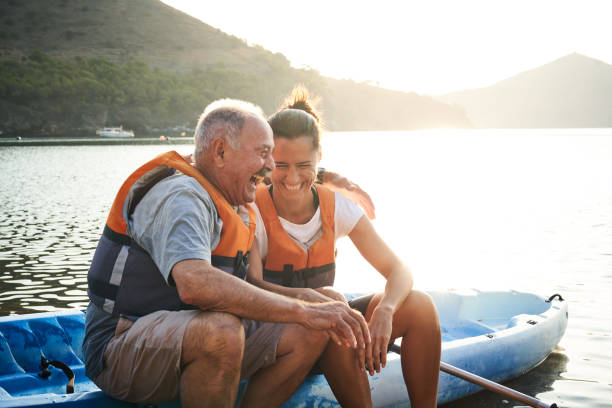 istock Man and daughter with arm around sitting on kayak 1177929332