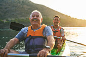 Smiling father and son kayaking on river