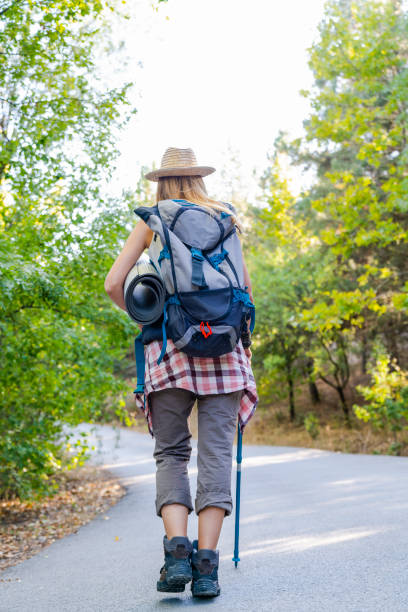 istock traveler woman with backpack walks on road 1177933658