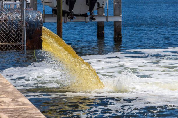 água amarela não tratada crua ou o esgoto que está sendo bombeado em um lago azul-hollywood, florida, eua - pumped - fotografias e filmes do acervo