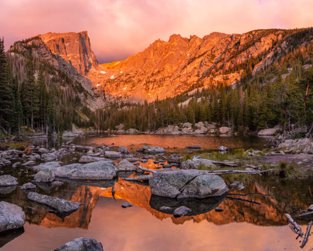 Colorful and Quiet Sunrise on Dream Lake A glorious pink and amber sunrise on Dream Lake in Rocky Mountain National Park, Colorado. hallett peak stock pictures, royalty-free photos & images