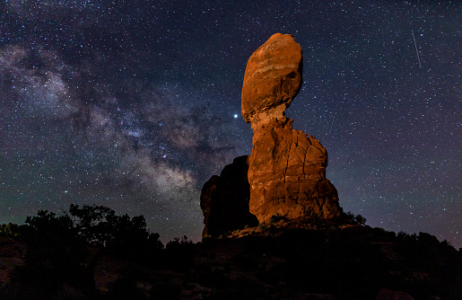 The Milky Way and 4 shooting stars behind balanced Rock ain Arches National Park, Utah.