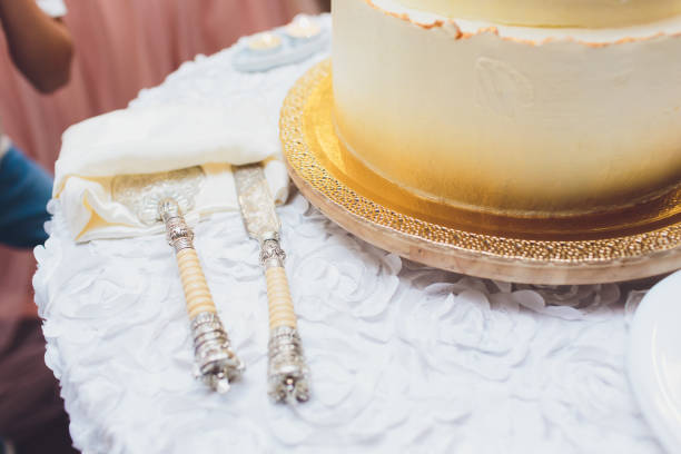 istock Three-tiered white wedding cake decorated with flowers from mastic on a white wooden table. Picture for a menu or a confectionery catalog with copy space. 1177943238