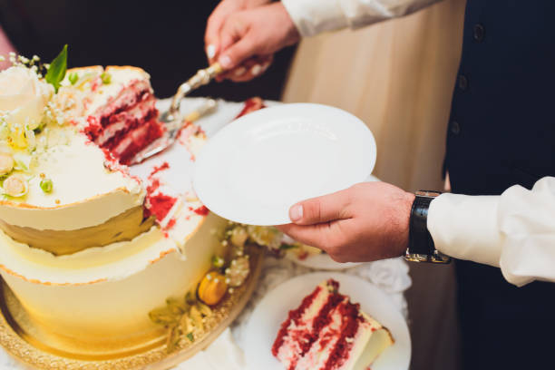 istock Three-tiered white wedding cake decorated with flowers from mastic on a white wooden table. Picture for a menu or a confectionery catalog with copy space. 1177943252