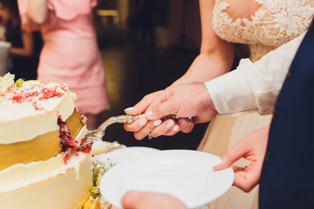 istock Three-tiered white wedding cake decorated with flowers from mastic on a white wooden table. Picture for a menu or a confectionery catalog with copy space. 1177943254