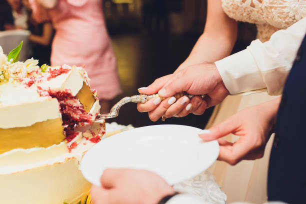 istock Three-tiered white wedding cake decorated with flowers from mastic on a white wooden table. Picture for a menu or a confectionery catalog with copy space. 1177943257