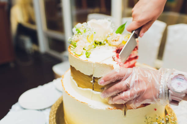istock Three-tiered white wedding cake decorated with flowers from mastic on a white wooden table. Picture for a menu or a confectionery catalog with copy space. 1177943259